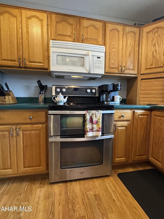 kitchen with range with two ovens and light hardwood / wood-style flooring