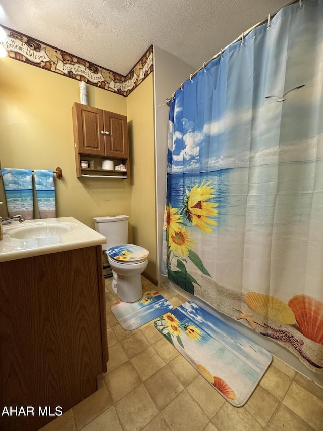 bathroom featuring a shower with curtain, vanity, a textured ceiling, and toilet