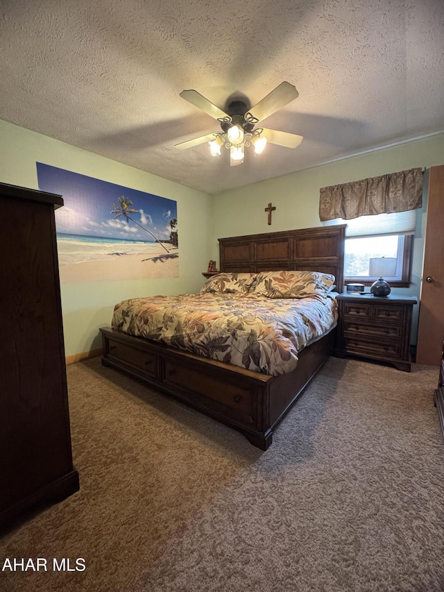 bedroom with ceiling fan, carpet flooring, and a textured ceiling