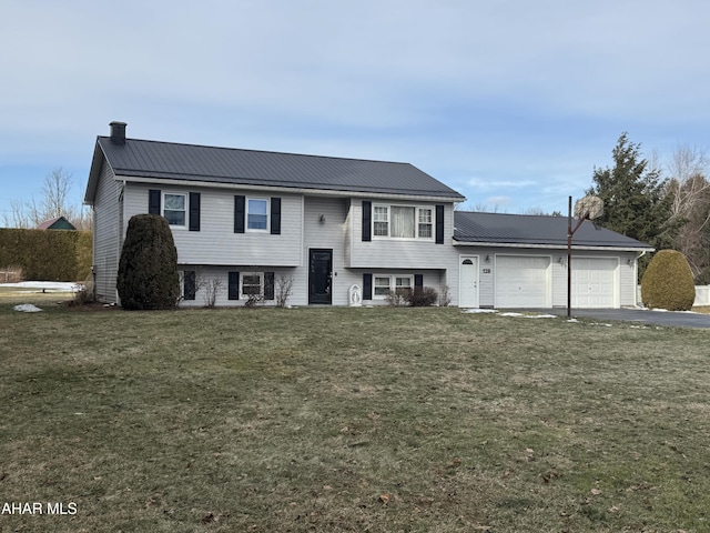 bi-level home featuring a garage and a front lawn