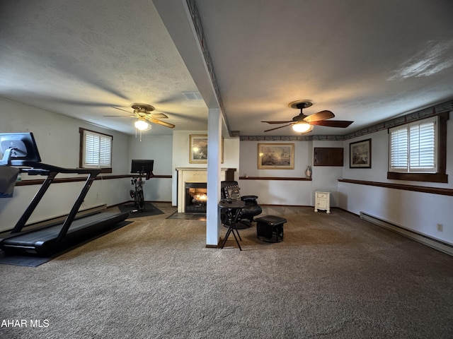 workout room featuring ceiling fan, a baseboard radiator, and a textured ceiling