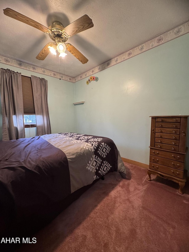 bedroom with ceiling fan, carpet floors, and a textured ceiling