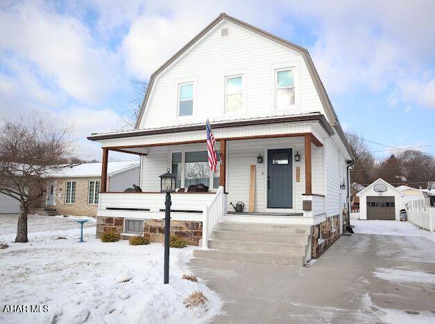 view of front facade featuring a garage, an outdoor structure, and covered porch