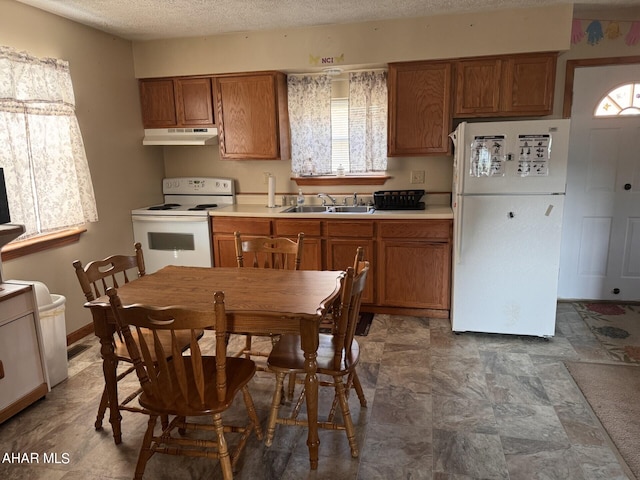 kitchen featuring a textured ceiling, white appliances, and sink