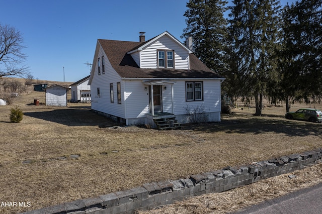 view of front of home with roof with shingles, an outdoor structure, and a chimney