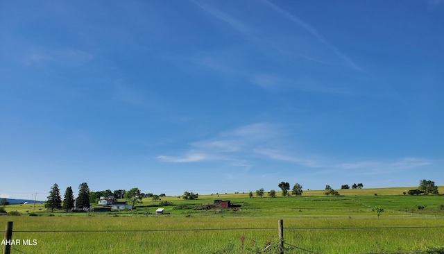 view of yard with a rural view and fence