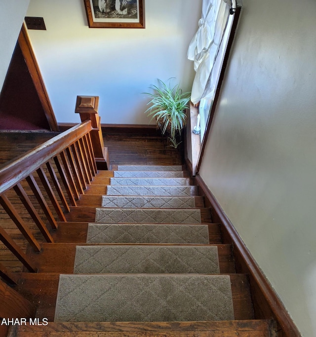 stairway with baseboards and wood finished floors