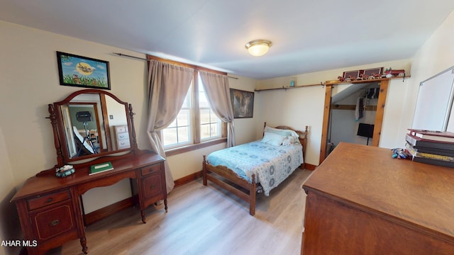 bedroom with light wood-type flooring and baseboards