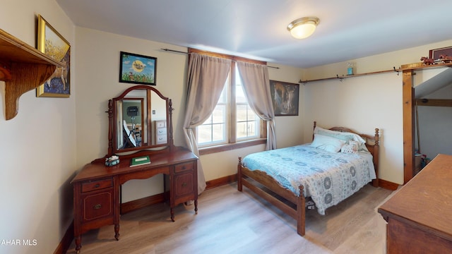 bedroom with wood finished floors and baseboards