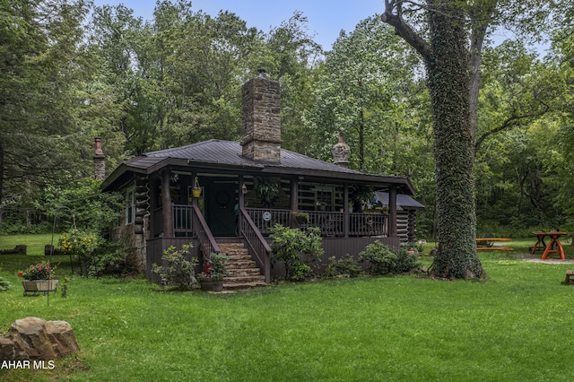 166 Mink Rd, Boswell, PA 15531 - view of front of house with a chimney, log siding, a front lawn, and covered porch