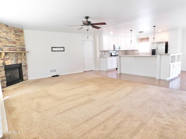 115 Spruce St, Smithmill, PA 16680 - unfurnished living room featuring ceiling fan, a fireplace, light carpet, and baseboards