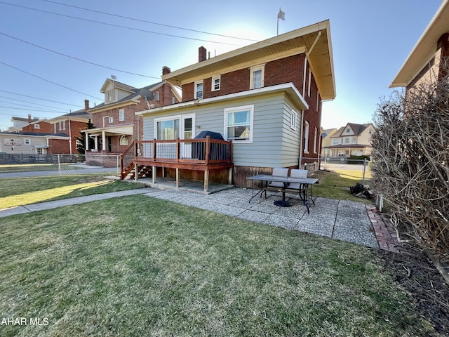 back of house with a patio, fence, a wooden deck, a lawn, and brick siding