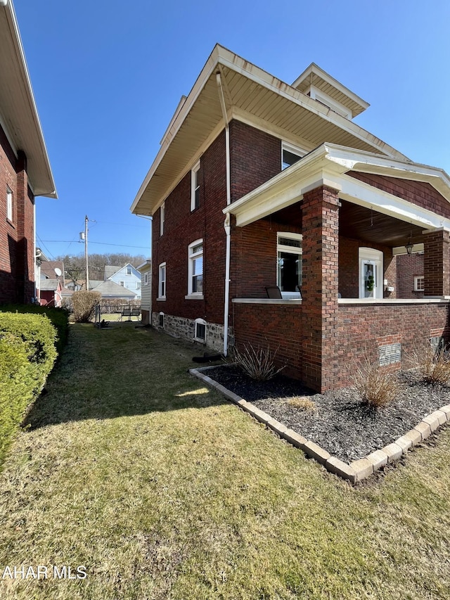 view of side of property with a yard and brick siding