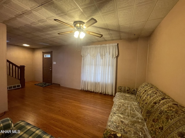 unfurnished living room with visible vents, a ceiling fan, and wood finished floors