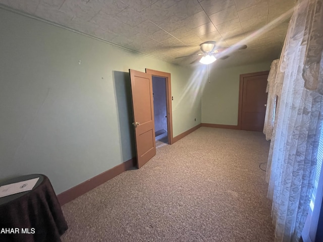 bonus room featuring baseboards, ceiling fan, and carpet flooring