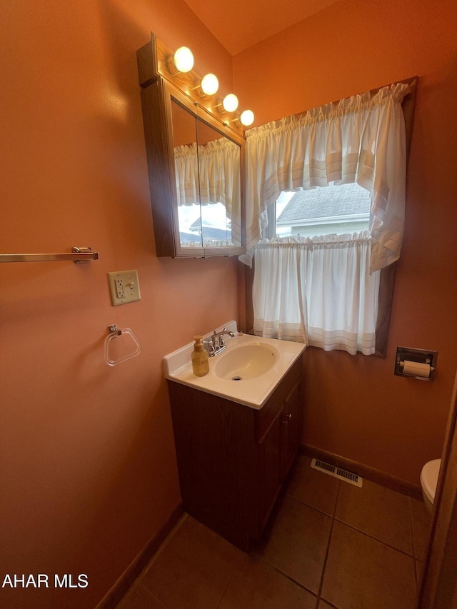bathroom with visible vents, baseboards, vanity, tile patterned floors, and toilet