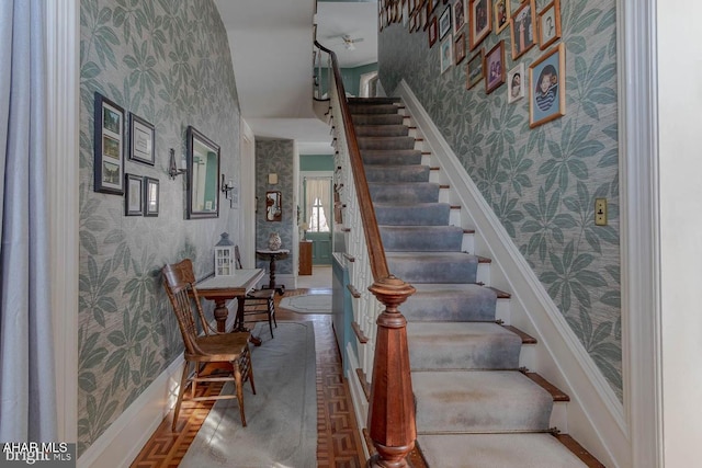 stairs featuring parquet flooring