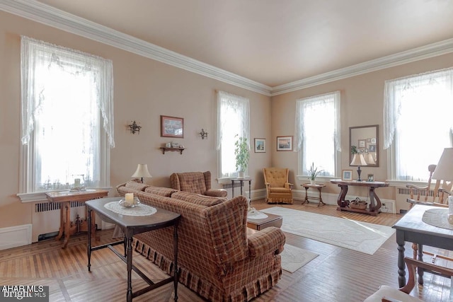 living room with light wood-type flooring, crown molding, radiator heating unit, and plenty of natural light