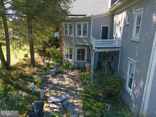 back of house featuring a balcony and a patio area