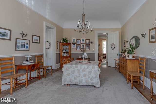 carpeted dining room featuring an inviting chandelier