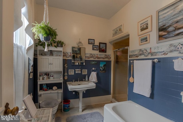 bathroom featuring separate shower and tub, tile walls, and toilet