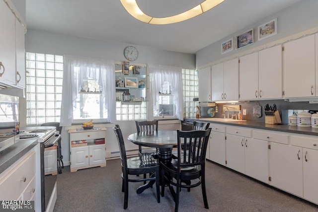 kitchen featuring white cabinetry, sink, range with electric cooktop, and a healthy amount of sunlight