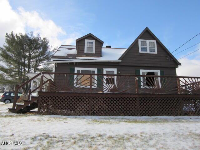 snow covered house with a deck