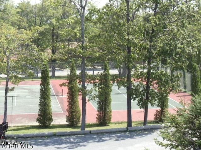 view of community featuring tennis court