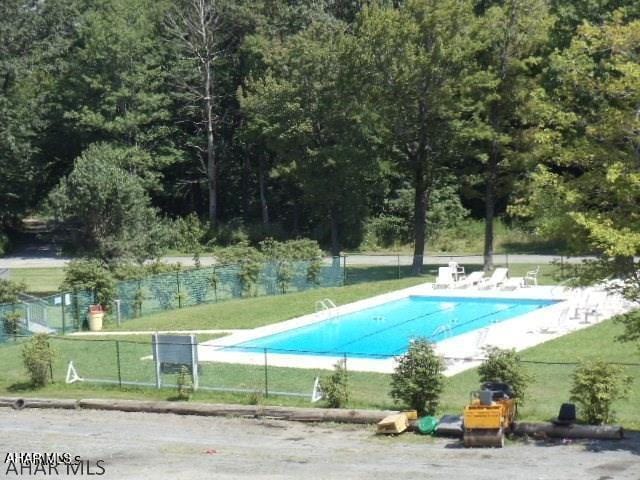 view of pool featuring a lawn