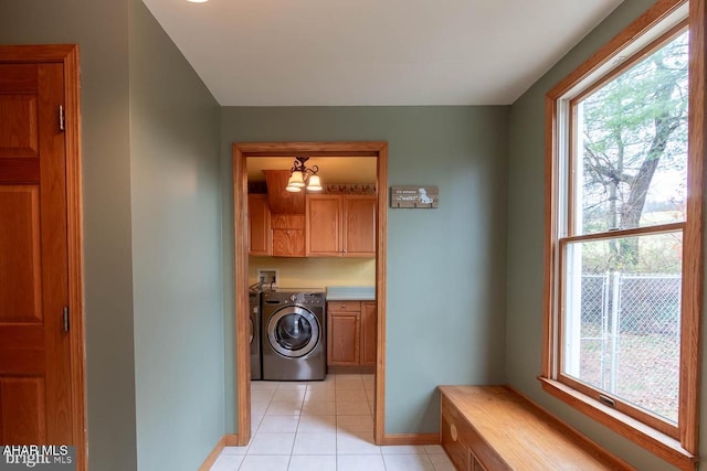 laundry area with light tile patterned floors, hookup for a washing machine, cabinets, and a healthy amount of sunlight