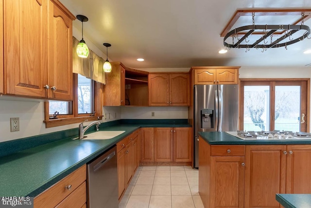 kitchen with appliances with stainless steel finishes, decorative light fixtures, sink, and light tile patterned floors