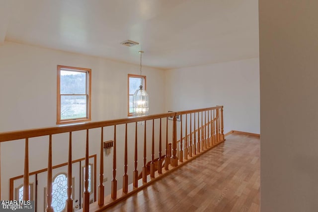 hallway featuring light hardwood / wood-style floors and a chandelier