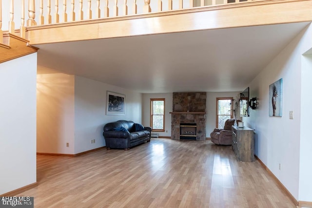 unfurnished living room with baseboard heating, a fireplace, and light hardwood / wood-style floors