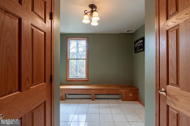 mudroom featuring light tile patterned flooring, a baseboard heating unit, and a chandelier