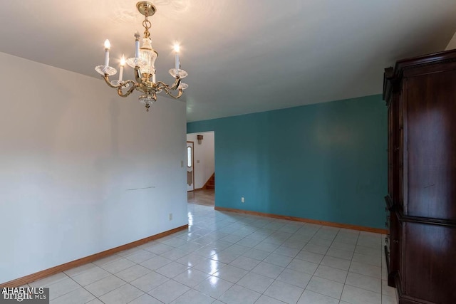 tiled empty room featuring a chandelier