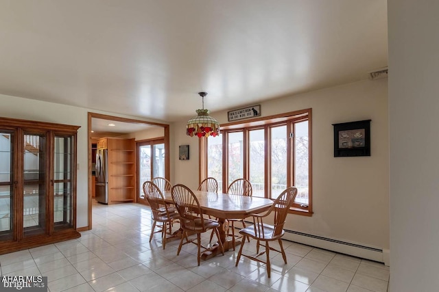 dining room featuring a baseboard radiator and light tile patterned flooring