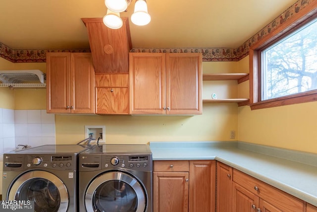 laundry room featuring cabinets and separate washer and dryer