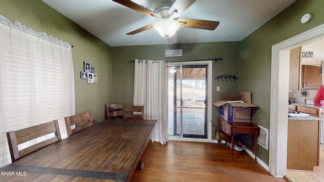 dining area with ceiling fan and dark wood-type flooring