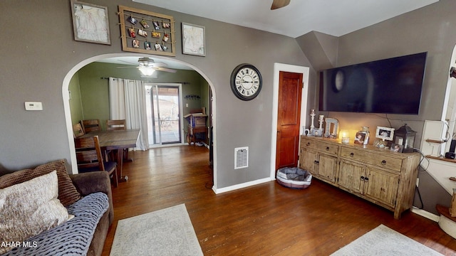 living room featuring ceiling fan and dark wood-type flooring