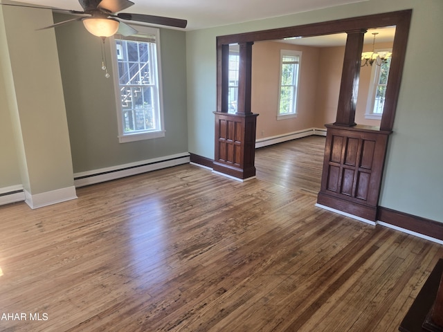 313 E John St, Bedford, PA 15522 - empty room featuring baseboard heating, wood finished floors, a chandelier, and a ceiling fan