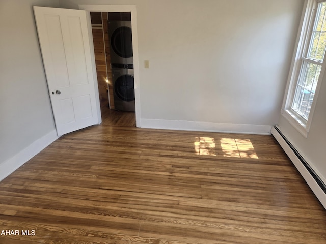 313 E John St, Bedford, PA 15522 - unfurnished room featuring stacked washing machine and dryer, a baseboard radiator, and wood finished floors