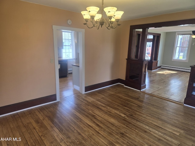 313 E John St, Bedford, PA 15522 - unfurnished dining area with baseboard heating, a chandelier, healthy amount of natural light, and dark wood-style flooring