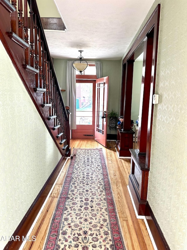 313 E John St, Bedford, PA 15522 - entrance foyer featuring hardwood / wood-style flooring, wallpapered walls, and stairs