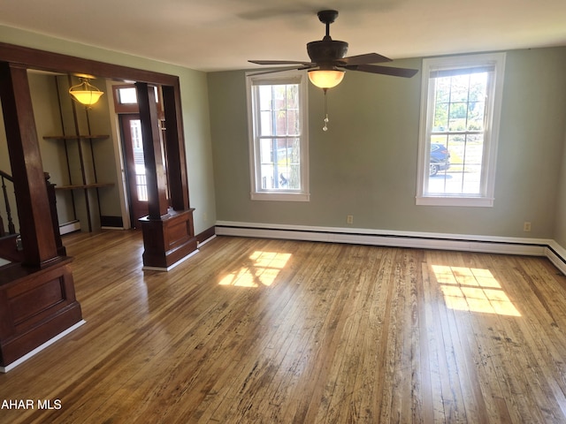 313 E John St, Bedford, PA 15522 - empty room with baseboard heating, wood-type flooring, a baseboard radiator, and plenty of natural light