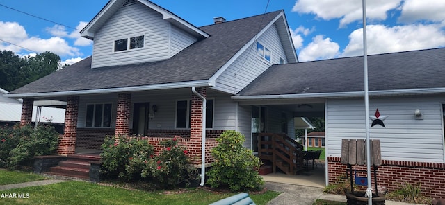 view of front of house featuring a porch, brick siding, and a shingled roof