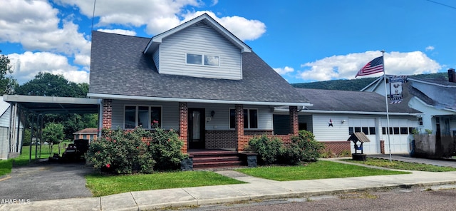 view of front of home with aphalt driveway, a porch, roof with shingles, a garage, and a carport