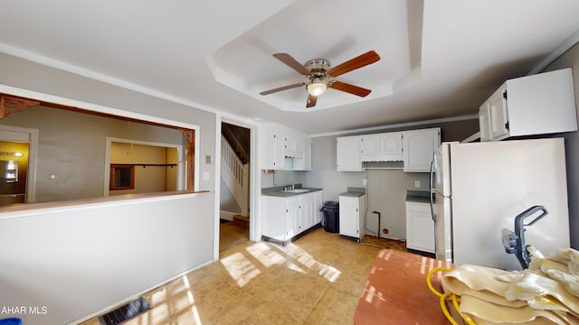 kitchen featuring ceiling fan, sink, white cabinets, and white refrigerator