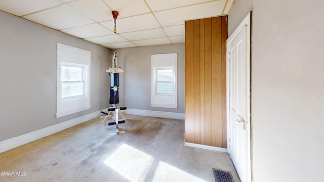 workout area featuring a paneled ceiling and light carpet