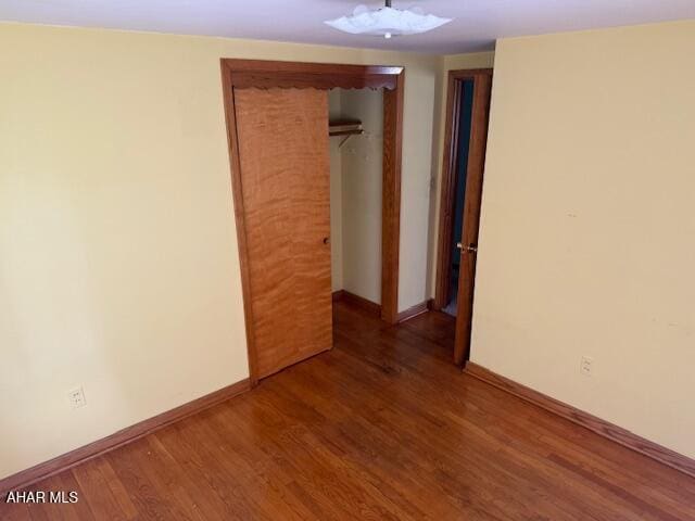 unfurnished room featuring wood finished floors and baseboards