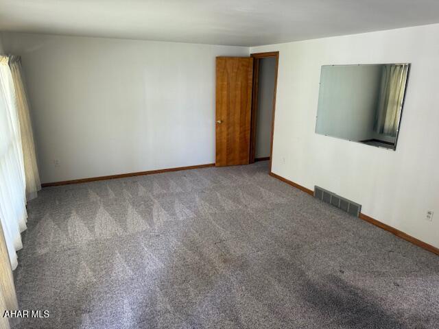 carpeted spare room with baseboards